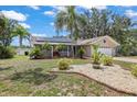 Beautifully landscaped front yard with palm trees, decorative rocks, and a well-maintained lawn at 5761 Colonial Dr, New Port Richey, FL 34653