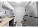 Clean kitchen with stainless steel appliances, white cabinets, and a view into the adjacent living area at 800 S Dakota Ave # 241, Tampa, FL 33606