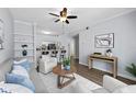 Open living room with hardwood floors, white furniture, ceiling fan, and view into the kitchen with barstool seating at 800 S Dakota Ave # 241, Tampa, FL 33606