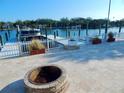 Waterfront backyard features a fire pit, boat dock and lift, and manicured landscaping at 8025 Island Dr, Port Richey, FL 34668