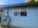 The exterior of a light blue house, showing a window with an air conditioner at 8203 N Semmes St, Tampa, FL 33604