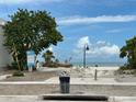 Scenic view of a beach access path with lush greenery leading to a sandy beach and ocean at 844 Bruce Ave, Clearwater Beach, FL 33767