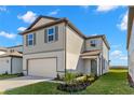 Charming home featuring a clean gray facade, manicured landscaping, and a two-car garage at 9066 Rally Spring Loop, Wesley Chapel, FL 33545