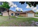 Inviting single-story home with a well-maintained lawn and an attached two-car garage at 107 Garland Cir, Palm Harbor, FL 34683