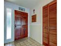 Welcoming foyer featuring tile flooring, a wood front door, and a closet at 107 Garland Cir, Palm Harbor, FL 34683