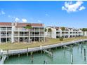 Beautiful condo complex from the waterway featuring outdoor balconies, chimneys, and well-kept landscaping at 12360 Capri N Cir # 106, Treasure Island, FL 33706