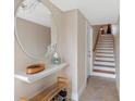 Inviting entryway with tiled floor, a decorative mirror, and a staircase leading to the upper level at 12360 Capri N Cir # 106, Treasure Island, FL 33706