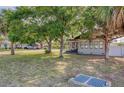 Exterior of home from across the yard, with mature trees and a well-manicured lawn at 12595 95Th N St, Largo, FL 33773