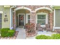 Welcoming front porch with stone accents, a decorative wreath, and cozy seating at 13608 Artesa Bell Dr, Riverview, FL 33579