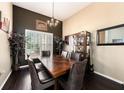 Elegant dining room boasts dark hardwood floors, wainscoting, contemporary chandelier, and ample natural light at 14042 Marlberry Way, Odessa, FL 33556