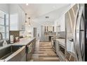 Modern kitchen with stainless steel appliances, quartz countertops, gray cabinetry, and wood-look flooring at 1421 Buckner Rd, Valrico, FL 33596