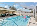 Inviting screened-in pool area with a sparkling pool, lounge seating, and covered patio, ideal for relaxation and entertainment at 1421 Buckner Rd, Valrico, FL 33596