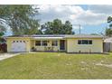 Charming one-story yellow home featuring a well-maintained lawn and welcoming front porch area at 1450 Seabreeze St, Clearwater, FL 33756