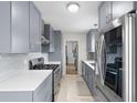 Modern kitchen featuring gray cabinets, stainless steel appliances, and white countertops, perfect for culinary enthusiasts at 1489 77Th N Ave, St Petersburg, FL 33702