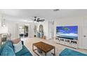 Bright and airy living room featuring modern decor, a comfortable blue sofa, and sliding doors to the backyard at 1489 77Th N Ave, St Petersburg, FL 33702
