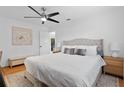 Serene main bedroom with a tufted headboard, hardwood floors, and ample natural light, creating a relaxing retreat at 1489 77Th N Ave, St Petersburg, FL 33702
