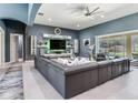 Spacious living room with custom wall shelving, contemporary design, and sliding glass doors to the pool at 16220 Lake Armistead Way, Odessa, FL 33556