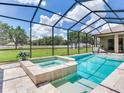 Screened-in pool area with pristine pool and integrated hot tub, perfect for relaxation and entertainment at 16220 Lake Armistead Way, Odessa, FL 33556