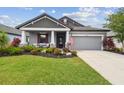 Charming single-Gathering home boasting a well-manicured lawn, vibrant flowers, and neutral gray tones at 19836 Hidden Glen Dr, Land O Lakes, FL 34638