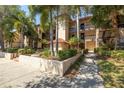 Exterior view of building showcases manicured landscaping, and mature palm trees at 2400 Feather Sound Dr # 1235, Clearwater, FL 33762