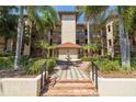 Well-maintained building exterior featuring lush landscaping, palm trees, and a decorative fountain centerpiece at 2400 Feather Sound Dr # 1235, Clearwater, FL 33762
