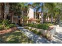 Exterior view of building with manicured landscaping, mature trees, and covered walkways at 2400 Feather Sound Dr # 1235, Clearwater, FL 33762