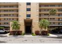 View of the building entrance showing covered parking and mature landscaping at 2617 Cove Cay Dr # 206, Clearwater, FL 33760