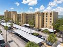 Low-angle view of the exterior elevation of the condo building highlighting a parking lot and surrounding trees at 2617 Cove Cay Dr # 206, Clearwater, FL 33760
