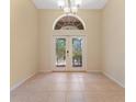 Elegant dining room featuring decorative glass french doors, and neutral tile flooring at 2637 Yukon Cliff Dr, Ruskin, FL 33570