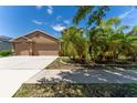 A delightful single-story home featuring a two-car garage and beautiful landscaping, including lush palm trees at 2637 Yukon Cliff Dr, Ruskin, FL 33570