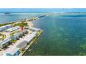 Aerial view showcasing townhomes along ocean waters with a bridge in the distance at 2643 St Josephs W Dr, Dunedin, FL 34698