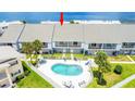 Aerial view of townhome with a community pool, balconies, green grass, near ocean waters at 2643 St Josephs W Dr, Dunedin, FL 34698