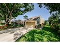 Charming home featuring lush landscaping, a driveway, and an attached two-car garage at 3174 Eagles Landing W Cir # 58, Clearwater, FL 33761
