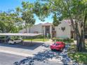 Exterior view of condo featuring covered parking, landscaping, and well-maintained facade at 3505 Tarpon Woods Blvd # N405, Palm Harbor, FL 34685