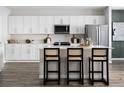 Bright kitchen showcasing white cabinets, stainless steel appliances, and a large center island with bar seating at 37255 Sagemoor Dr, Zephyrhills, FL 33541