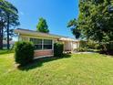 Inviting single-story home with lush green lawn and mature trees, offering shade and natural beauty at 3845 Edgemont Dr, New Port Richey, FL 34652