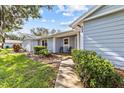 Charming single-story home with blue siding, lush landscaping, and inviting front porch at 39650 Us Highway 19 N # 553, Tarpon Springs, FL 34689