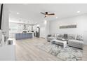 Open-concept living room featuring hardwood floors, gray sofa, and an adjacent kitchen with island at 4120 W North A St # 2, Tampa, FL 33609