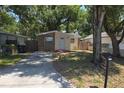 Single-story home featuring brick accents, a driveway, and mature trees at 4607 N 35Th St, Tampa, FL 33610