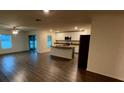 Spacious living room with wood floors adjacent to an island kitchen at 5407 Kedgewick Ln, North Port, FL 34288