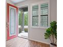 Bright entryway featuring a decorative glass door, modern shutters and hardwood floors at 5613 Kingsley Corner Way, Lithia, FL 33547