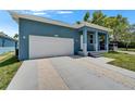 Stylish one-story home with a light blue exterior, white garage door, and decorative rock driveway at 6097 Vermont Ave, New Port Richey, FL 34653