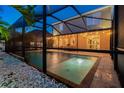 Screened-in pool featuring a spa and an outdoor dining area with string lights above at 7705 S Sparkman St, Tampa, FL 33616