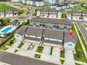 Aerial view of a townhome community with a swimming pool and ample parking at 7709 Imagination Pl, Wesley Chapel, FL 33545