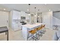 Modern kitchen featuring white cabinets, stainless steel appliances, and a large island with seating at 7709 Imagination Pl, Wesley Chapel, FL 33545