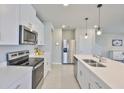 Stylish kitchen showcasing stainless steel appliances, white cabinets, and a sleek countertop at 7709 Imagination Pl, Wesley Chapel, FL 33545
