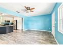 Spacious open living area featuring wood-look floors, bright light, and a view of the kitchen at 8528 Iris Ave, Seminole, FL 33777