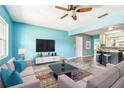 Open living room showcasing wood-look flooring, modern furnishings, and a view into the kitchen at 8528 Iris Ave, Seminole, FL 33777