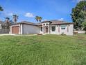 Charming single-story home featuring a well-manicured lawn, two-car garage, and neutral color scheme at 9416 Bullfrog Court, Gibsonton, FL 33534