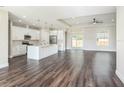 Open-concept kitchen with a large island, stainless steel appliances, and dark wood flooring at 9416 Bullfrog Court, Gibsonton, FL 33534